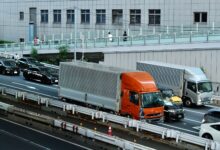Traffic scene with trucks and cars in Tokyo, Japan, showcasing urban life and transportation.