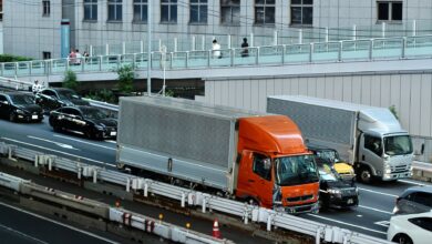 Traffic scene with trucks and cars in Tokyo, Japan, showcasing urban life and transportation.