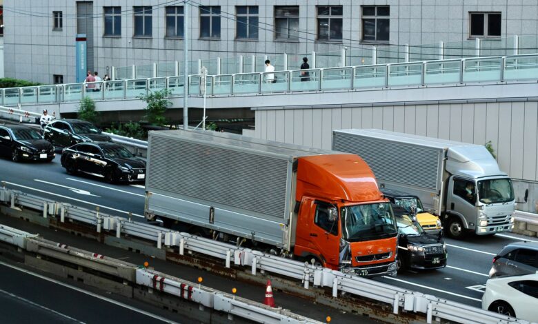 Traffic scene with trucks and cars in Tokyo, Japan, showcasing urban life and transportation.