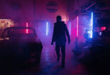 A mechanic in a neon-lit garage works amidst vibrant pink and blue lights, creating a moody, cyberpunk atmosphere.