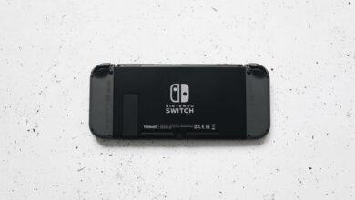 A close-up of a Nintendo Switch console placed on a textured marble surface, highlighting the device's sleek design.