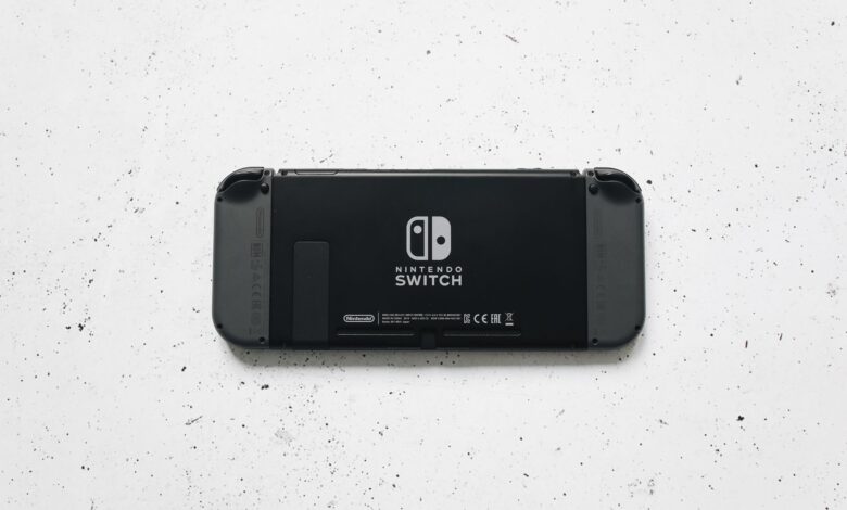 A close-up of a Nintendo Switch console placed on a textured marble surface, highlighting the device's sleek design.