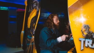 Bearded man passionately gaming at an arcade, focused and engaged.