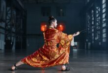 Martial artist performs with sword in elaborately patterned kimono.
