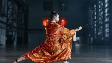 Martial artist performs with sword in elaborately patterned kimono.