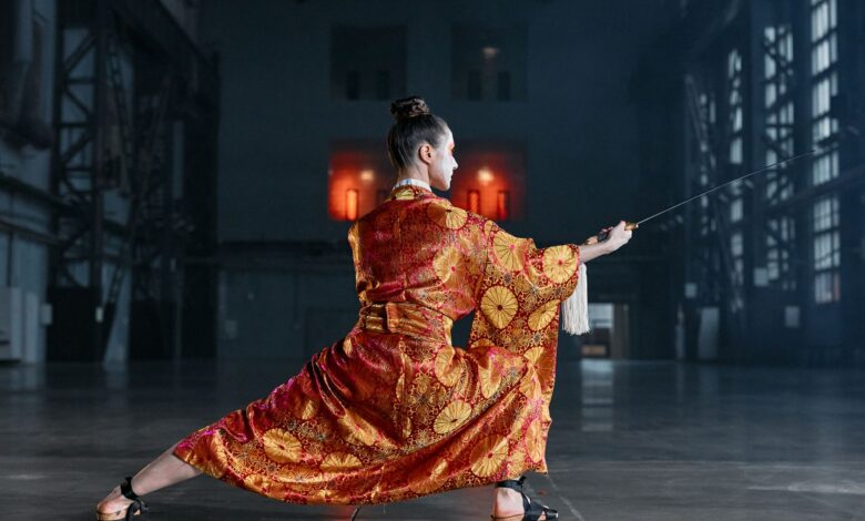 Martial artist performs with sword in elaborately patterned kimono.