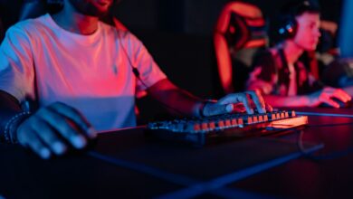 Two focused gamers in a neon-lit arena, wearing headphones and gaming intensely.