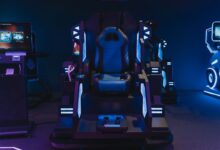 High-tech gaming simulator chair in an indoor arcade setting with neon lights.