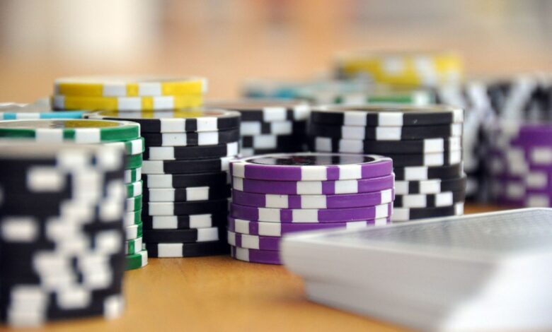 A close-up shot of stacked poker chips and playing cards on a table, perfect for casino and gambling themes.