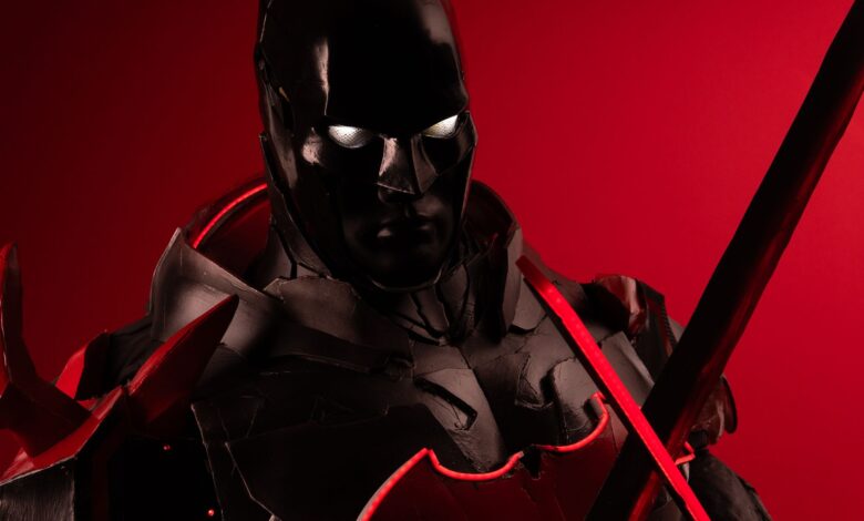 Striking cosplay portrait featuring a character in black and red armor with a dramatic red background.