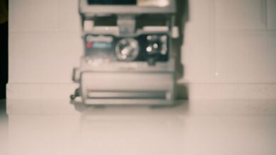 Blurred vintage Polaroid camera on a white surface creating a nostalgic feel.