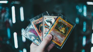 A hand holds collectible Charizard Pokemon cards with a blurred bokeh background. Perfect for trading card enthusiasts.