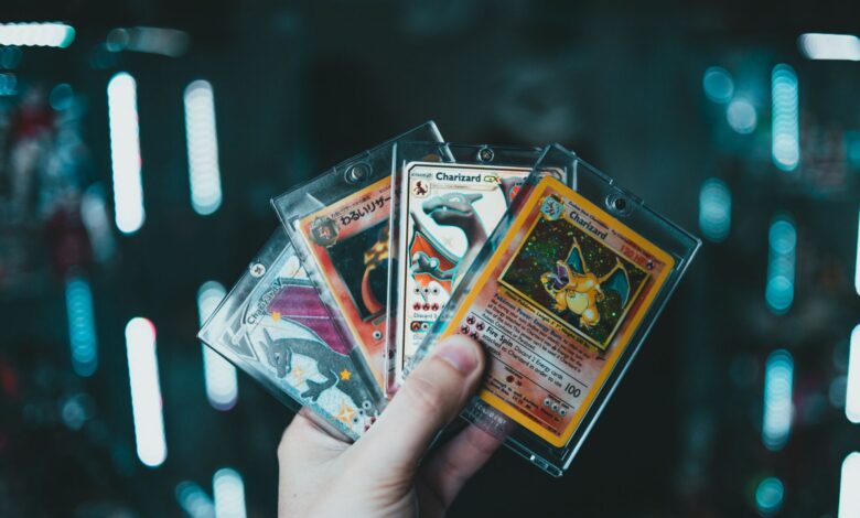 A hand holds collectible Charizard Pokemon cards with a blurred bokeh background. Perfect for trading card enthusiasts.