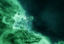 Vivid cosmic nebula with contrasting green clouds and starry sky.