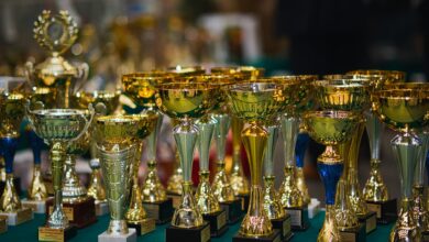 Array of golden trophies on a table, reflecting victory and achievement.
