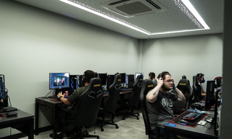 Group of gamers intensely playing video games in a modern esports center.