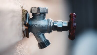 Detailed close-up of a metal faucet mounted on an exterior wall with visible textures.