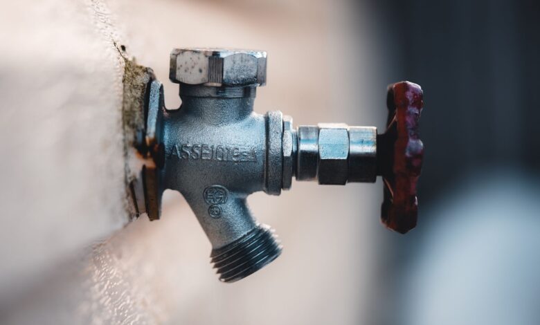 Detailed close-up of a metal faucet mounted on an exterior wall with visible textures.