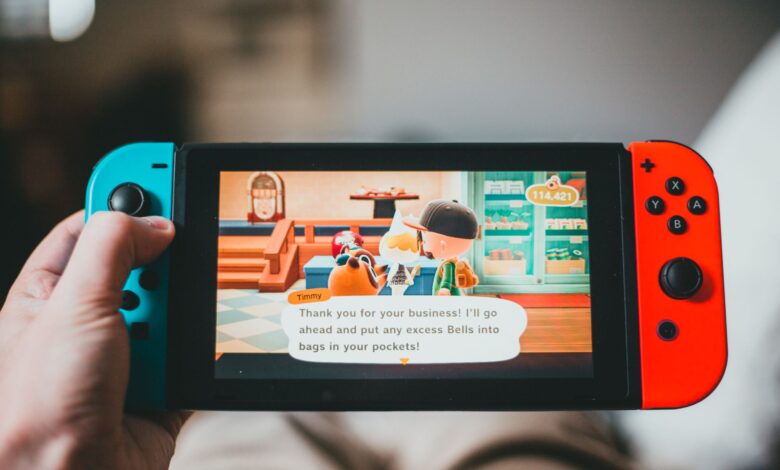 Crop anonymous person playing videogame while using game console and sitting at home on blurred background