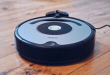 Close-up of a robotic vacuum cleaner operating on a hardwood floor, showcasing modern cleaning technology.