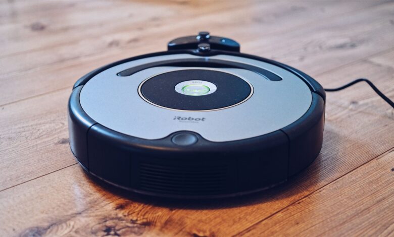 Close-up of a robotic vacuum cleaner operating on a hardwood floor, showcasing modern cleaning technology.