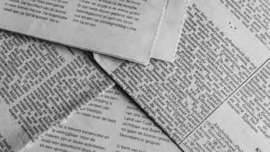Black and white close-up of newspaper pages with text in Dutch.