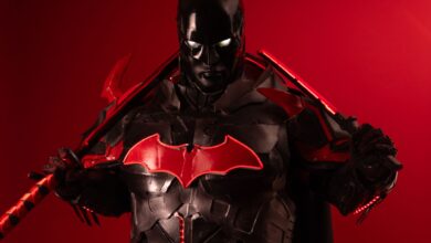 Dramatic Batman inspired cosplay featuring black and red armor against a vibrant red background.