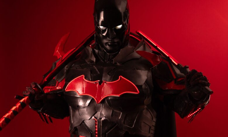Dramatic Batman inspired cosplay featuring black and red armor against a vibrant red background.