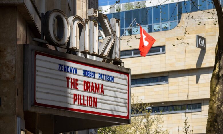 Cinema marquee displaying movie title in urban setting with Swiss flag nearby.