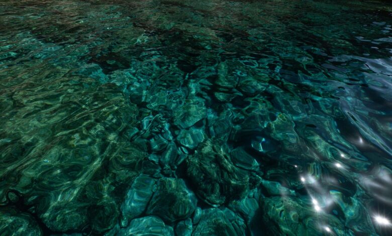 A mesmerizing view of turquoise ocean water reflecting sunlight, revealing underwater textures and patterns.