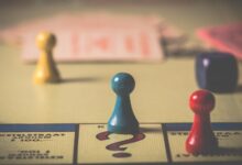 Close-up of a classic board game with vibrant tokens and dice on a playing board.