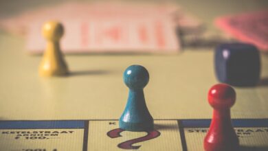 Close-up of a classic board game with vibrant tokens and dice on a playing board.