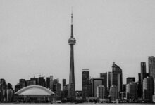 A black and white view of Toronto's skyline featuring the iconic CN Tower and modern architecture.