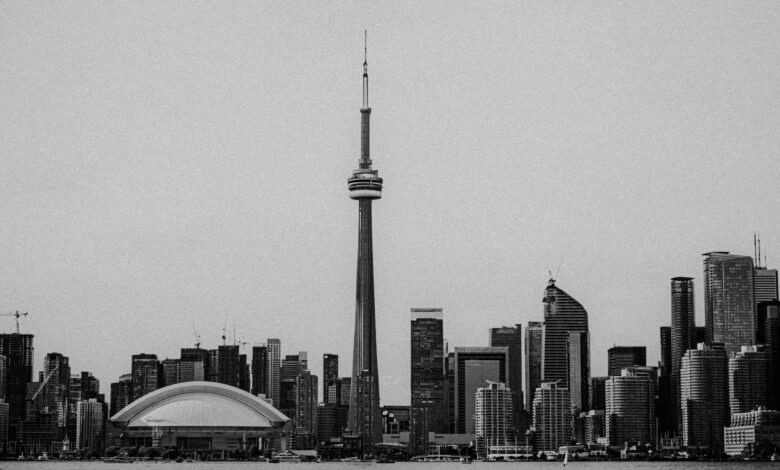 A black and white view of Toronto's skyline featuring the iconic CN Tower and modern architecture.