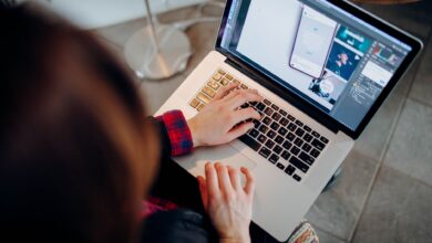 Close-up of a person working on a laptop with graphic design software.