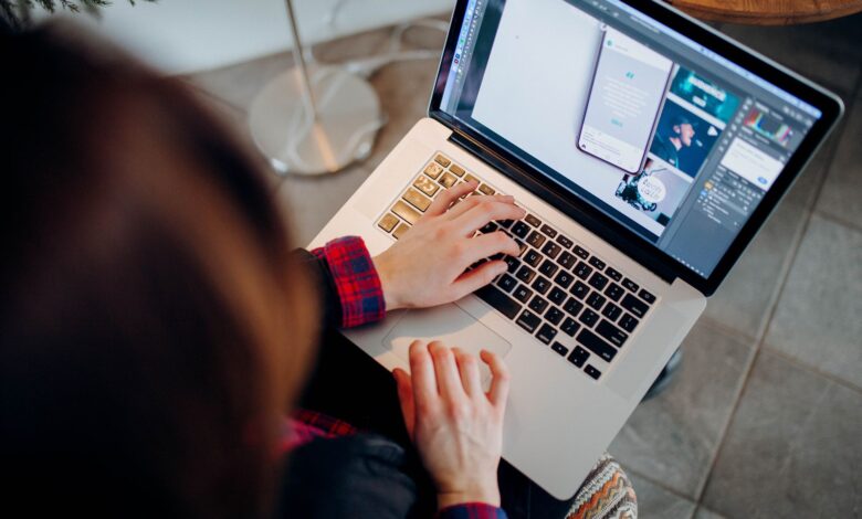 Close-up of a person working on a laptop with graphic design software.