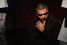 Thoughtful man in a dark setting, reflecting deeply.