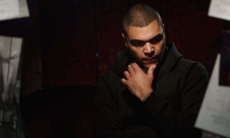 Thoughtful man in a dark setting, reflecting deeply.