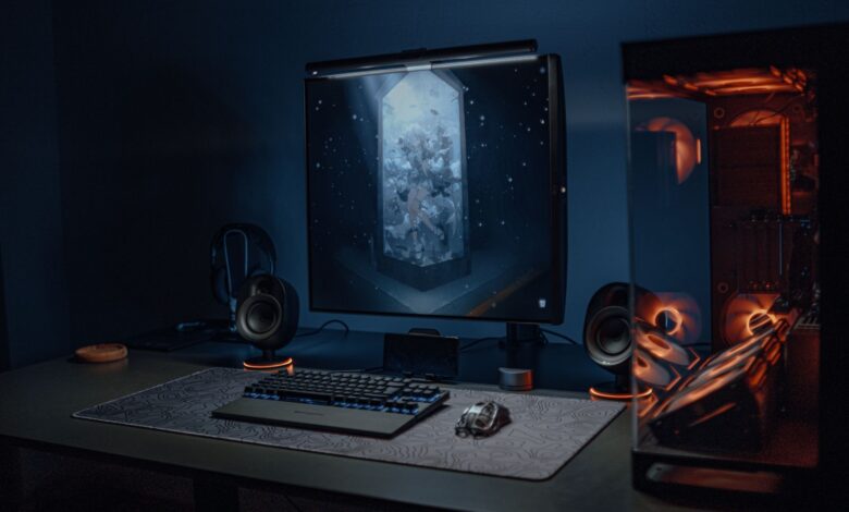 A stylish gaming setup featuring a screen, keyboard, and PC with ambient lighting.
