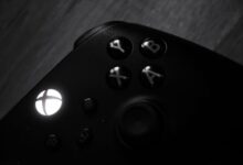 Monochrome close-up of a gaming controller highlighting buttons and logo.