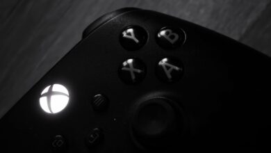 Monochrome close-up of a gaming controller highlighting buttons and logo.