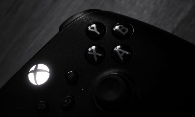 Monochrome close-up of a gaming controller highlighting buttons and logo.