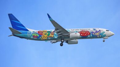 Garuda Indonesia airplane featuring Pokémon artwork flying against a clear blue sky.