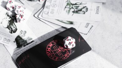 A collection of tarot cards and gaming dice on a tabletop, featuring mystical illustrations.