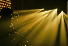 Silhouetted soldiers with dramatic beams of light in a military setting.