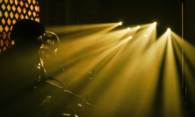 Silhouetted soldiers with dramatic beams of light in a military setting.