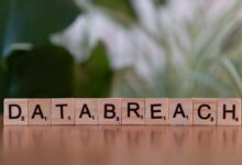 Close-up of Scrabble tiles spelling 'data breach' on a blurred background
