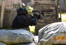 A player in protective gear engaged in a dynamic outdoor paintball match.