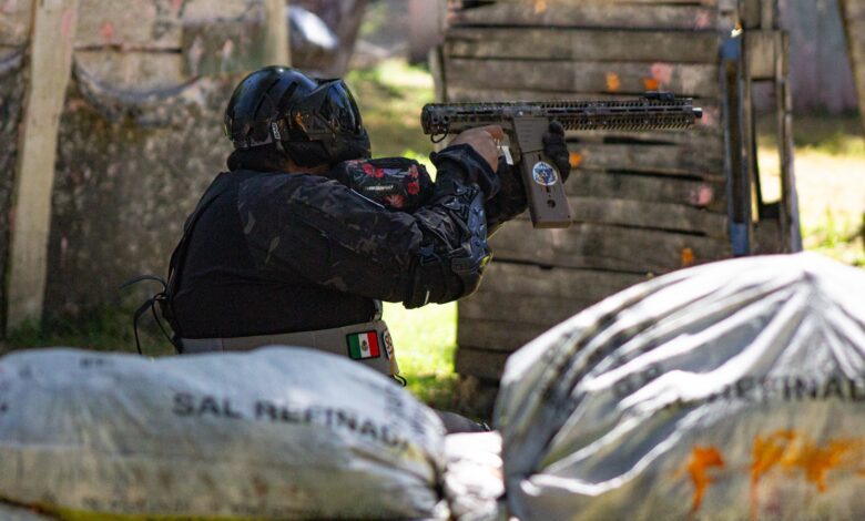A player in protective gear engaged in a dynamic outdoor paintball match.