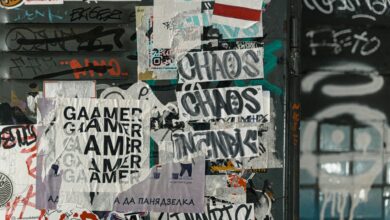 Vibrant urban scene of graffiti and layered posters on a city wall, capturing street art culture.